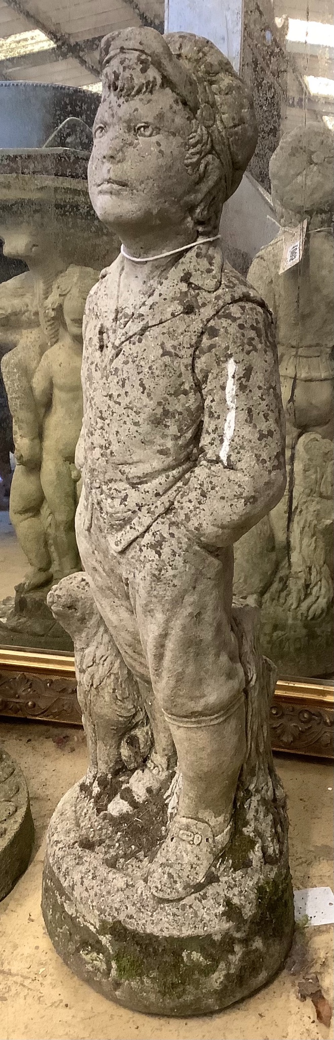 A reconstituted stone garden ornament of a boy with dog, height 69cm